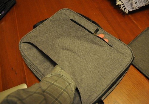 The rear pocket can be zipper open to use with rolling luggage.