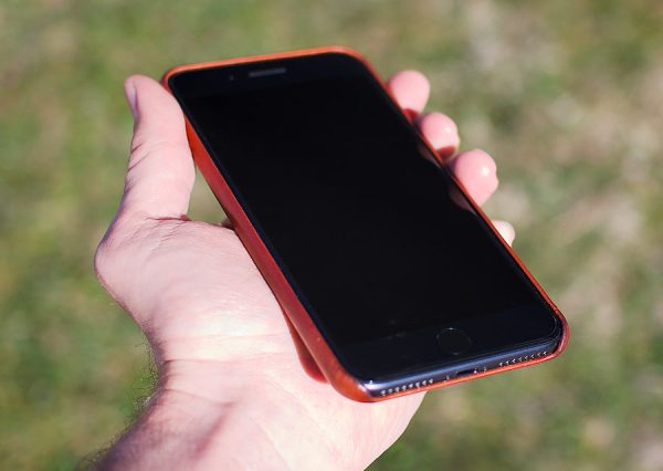 Hand holding iphone in brown leather case