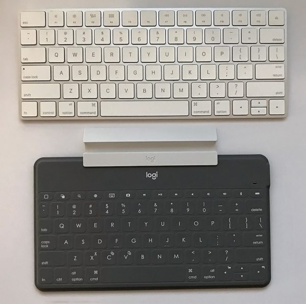 Apple Keyboard situated above Logitech Keyboard