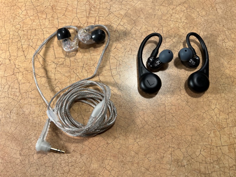 Shure AONIC 215 Gen 2 next to a pair of Shure SE215 wired in-ear headphones