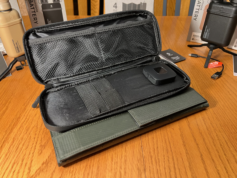 Solar panels folded up with pocket opened to show charger and pockets