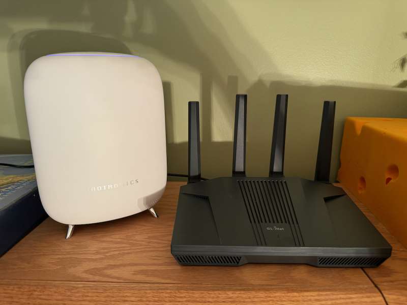 GL.iNet Flint 2 (MT6000) Router next to one of the TaoTronics routers it's going to replace