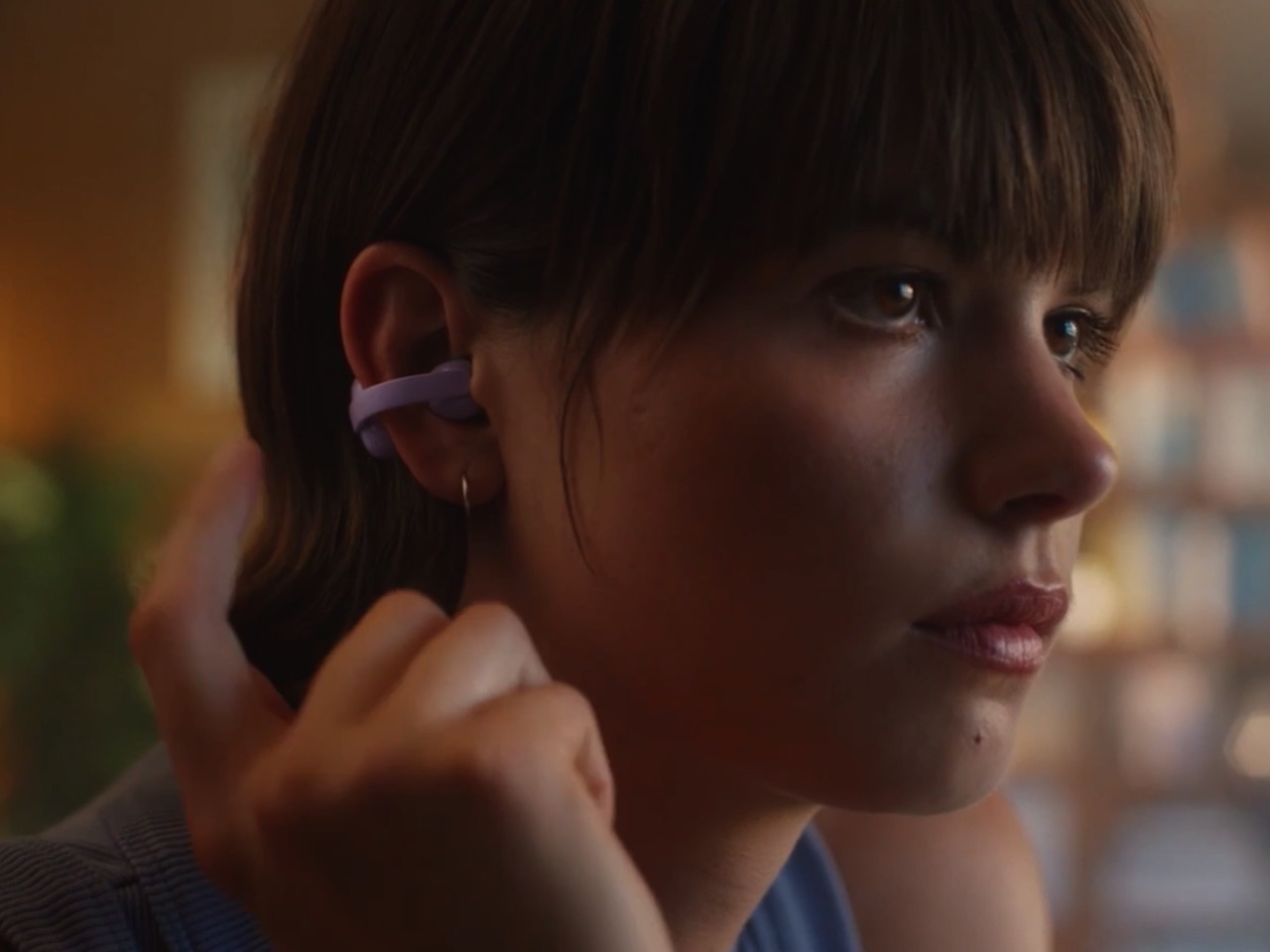 Person wearing purple clip earbuds.