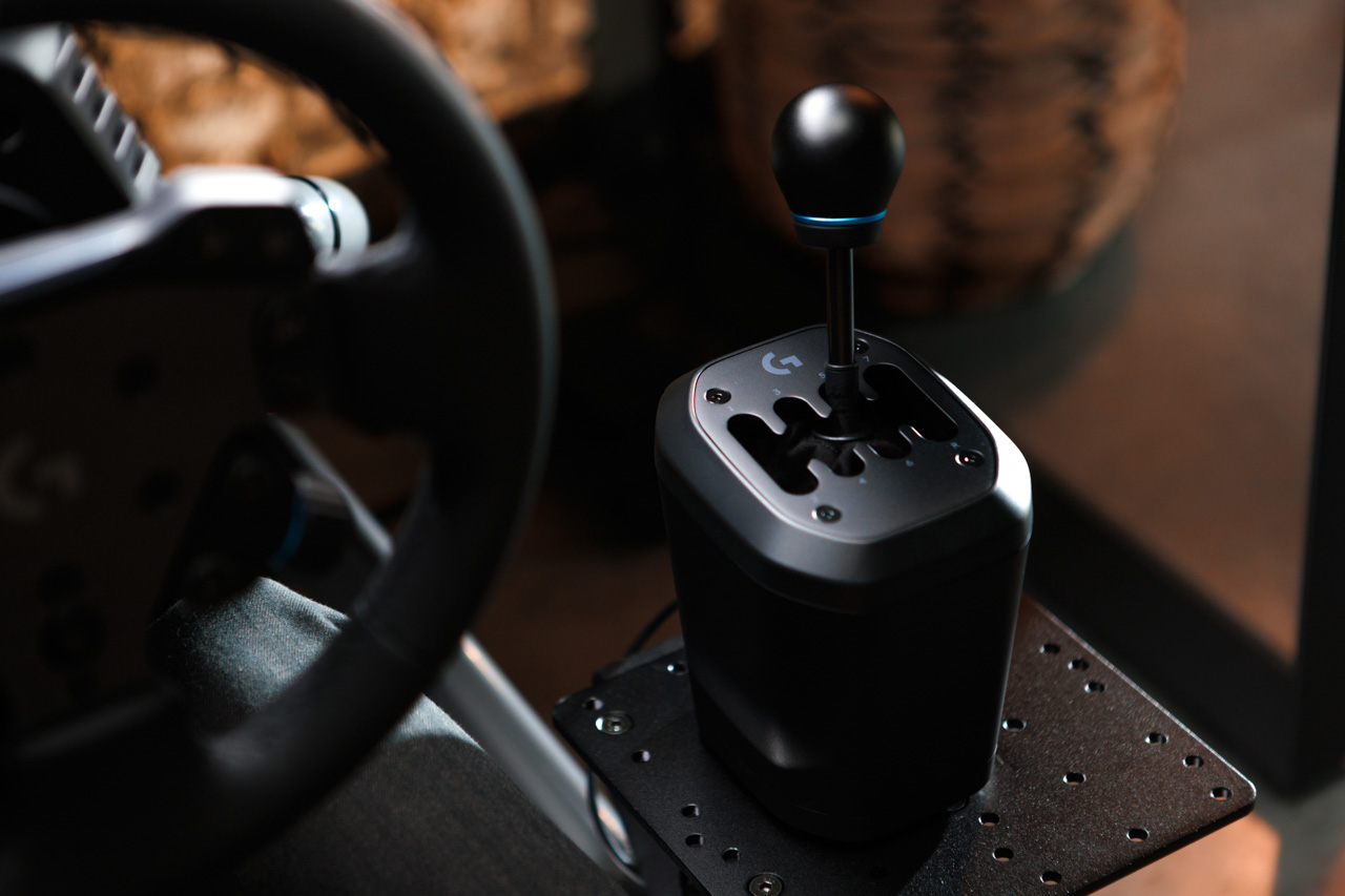 Logitech G RS H-Shifter sitting on a desk, showing the 7+R speed H-pattern gate layout, weighted aluminum knob, and steel and aluminum construction