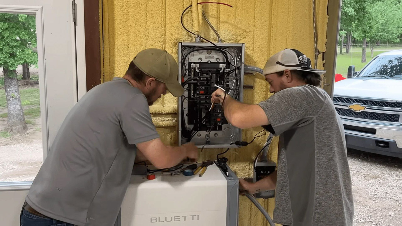 A sleek, white BLUETTI EnergyPro 13K whole home battery backup system installed against a modern garage wall next to a parked electric vehicle.