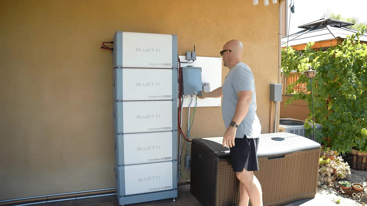A sleek, white BLUETTI EnergyPro 13K whole home battery backup system installed against a modern garage wall next to a parked electric vehicle.