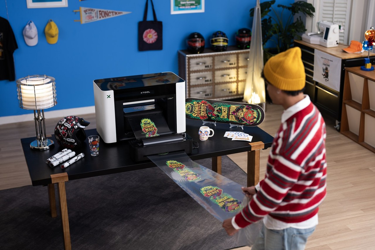 Person working with the xTool O1 Omni printer in a home studio