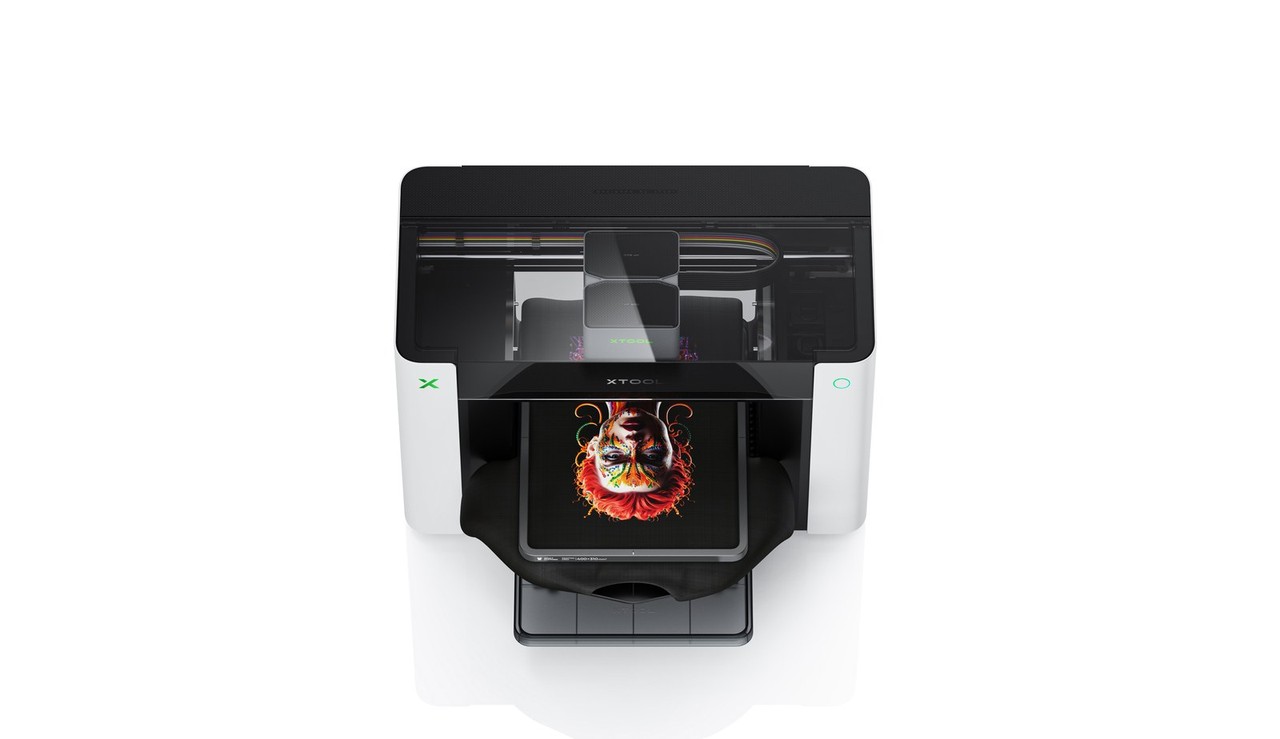 xTool O1 Omni printer in a workspace with finished custom items nearby