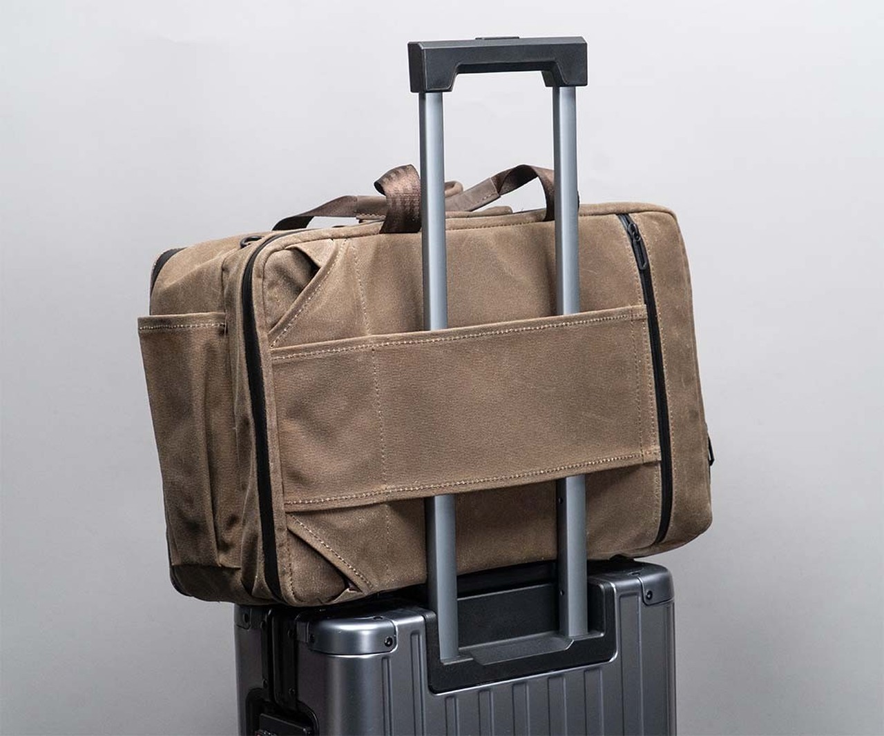 The Carryall attached to rolling luggage through its passthrough
