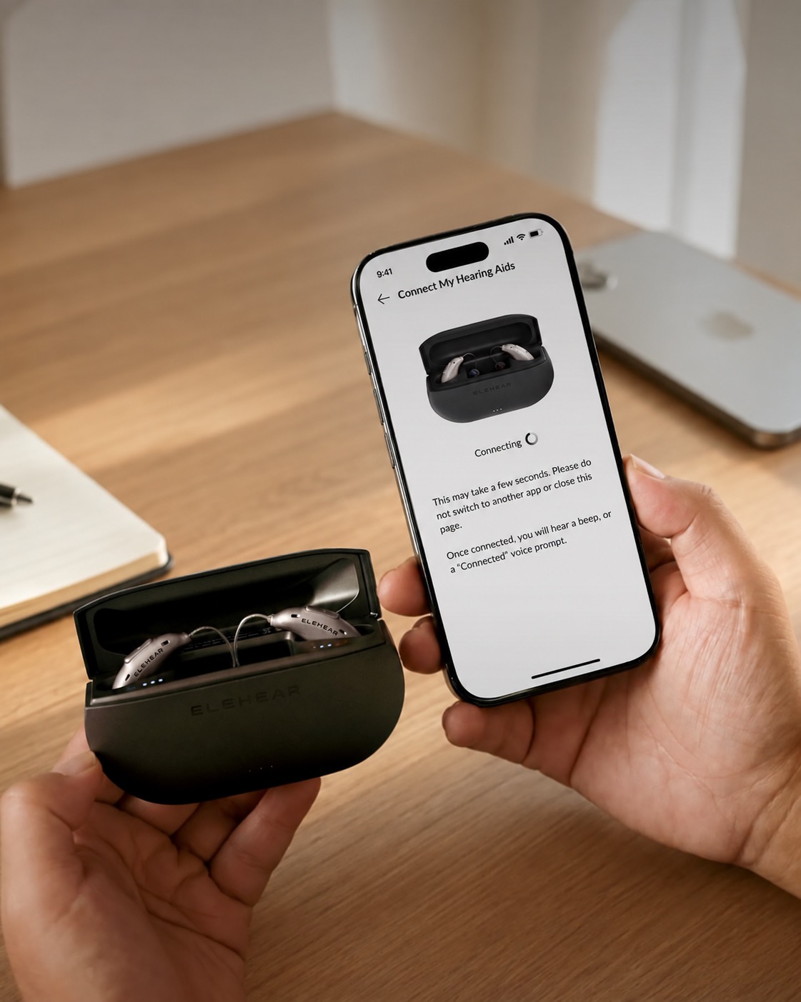 ELEHEAR hearing aids and charging case being connected to a phone.