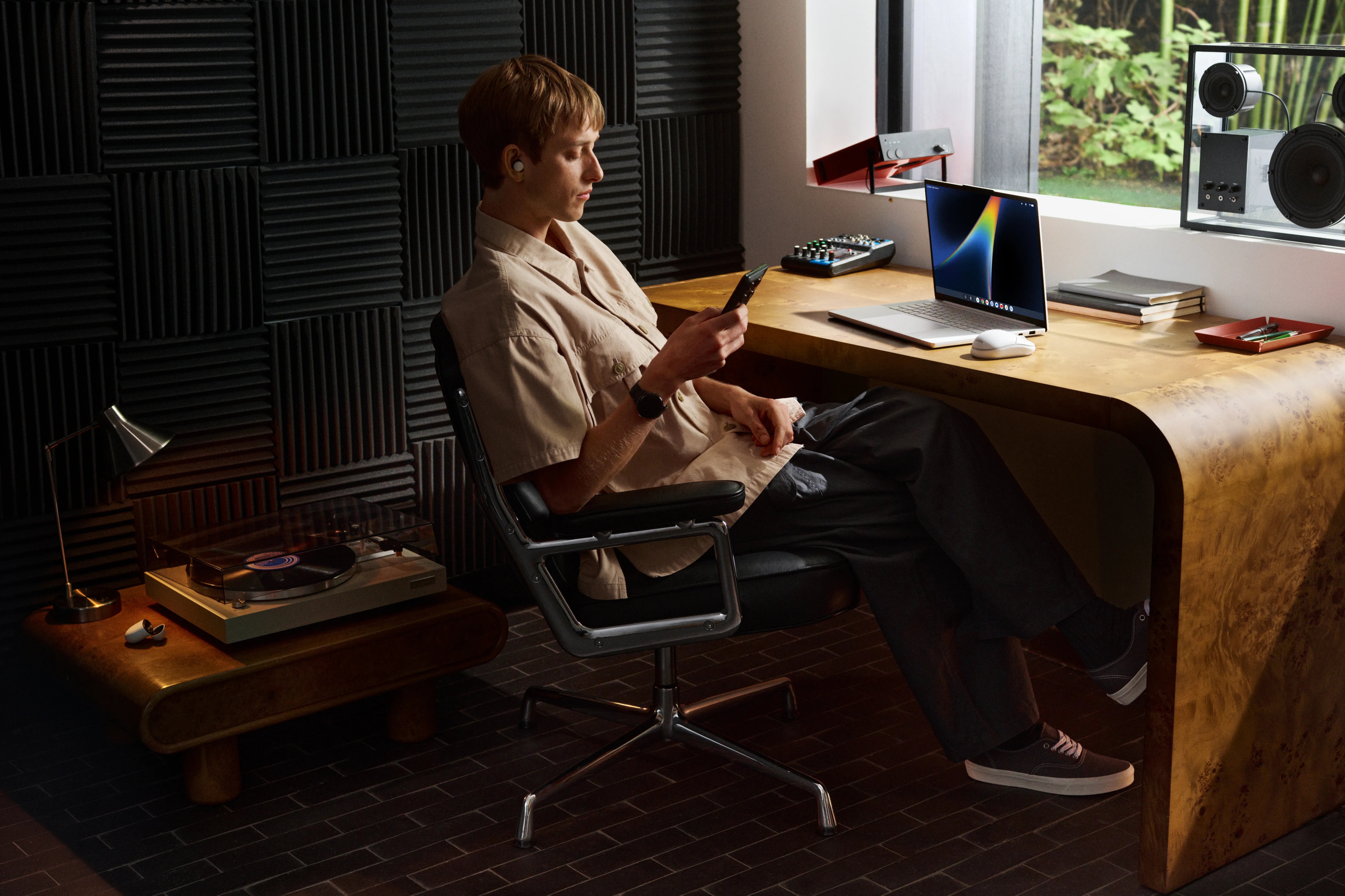 Person seated beside a Lenovo Googlebook 15 in a music studio
