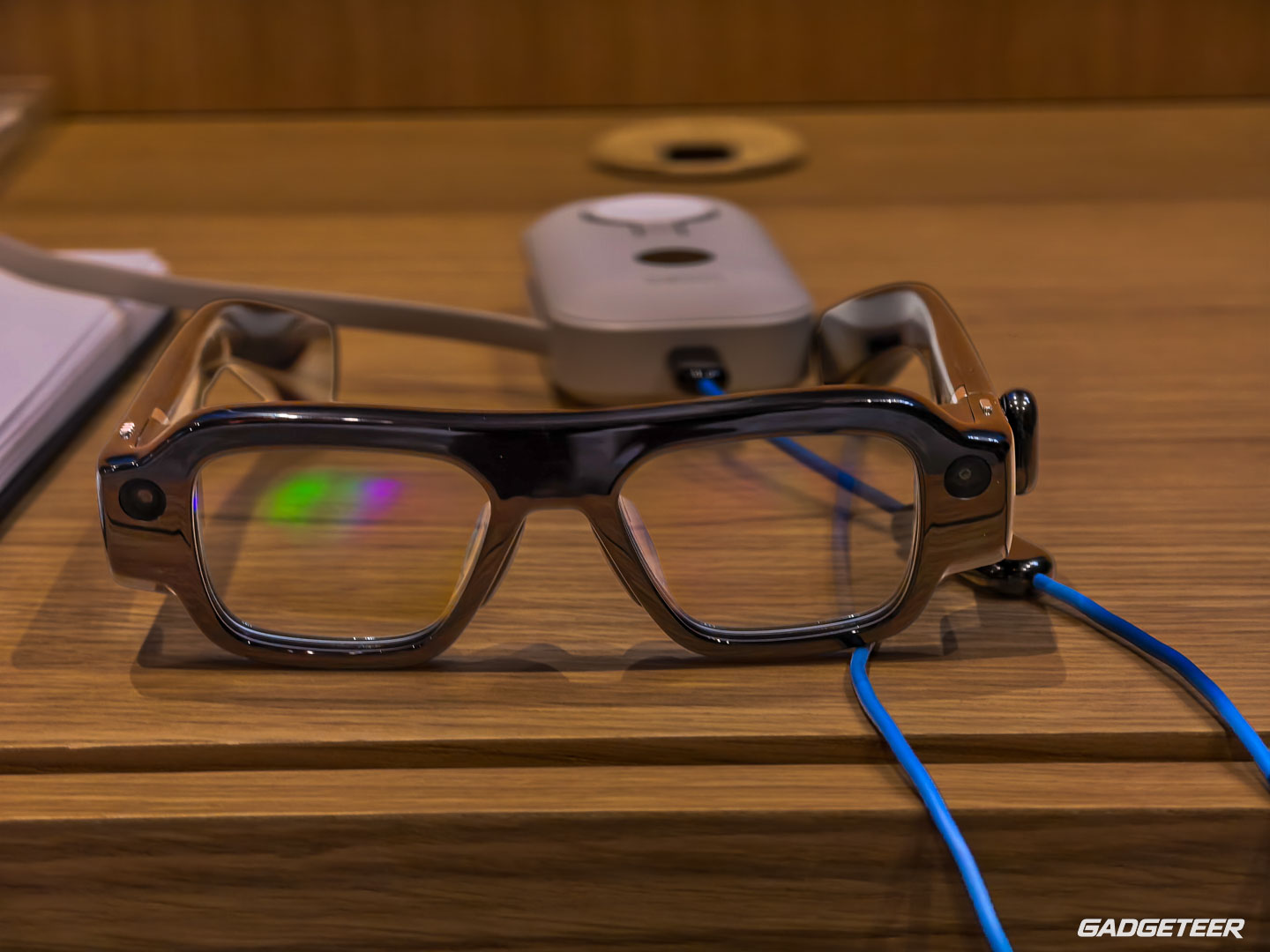 SPECS and a visible cable on the demo table; this image does not show wireless casting.