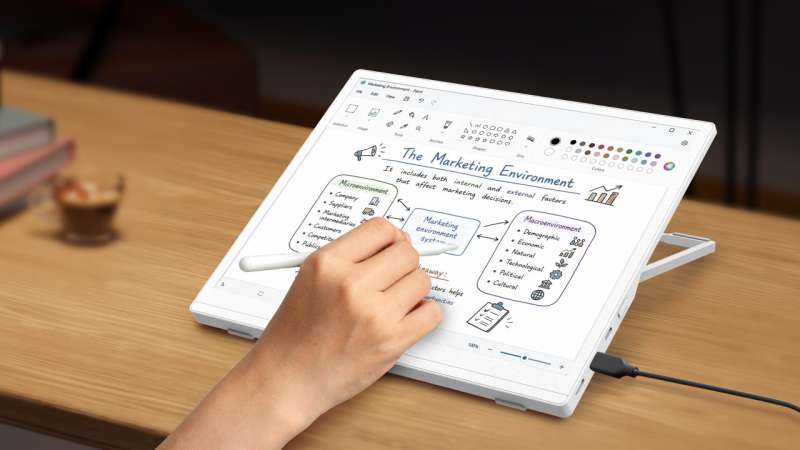 A person uses a stylus on the Acer EP130K color ePaper monitor at a desk