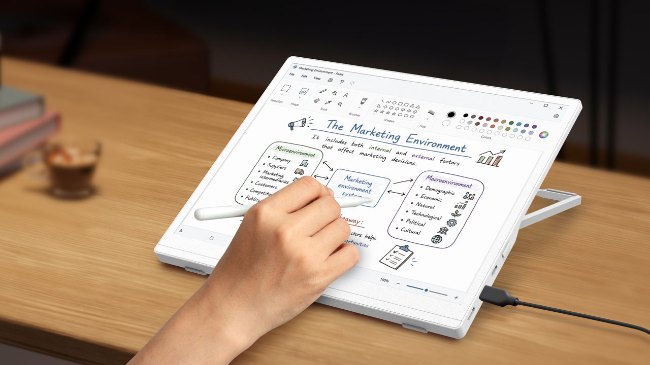 A person uses a stylus on the Acer EP130K color ePaper monitor at a desk