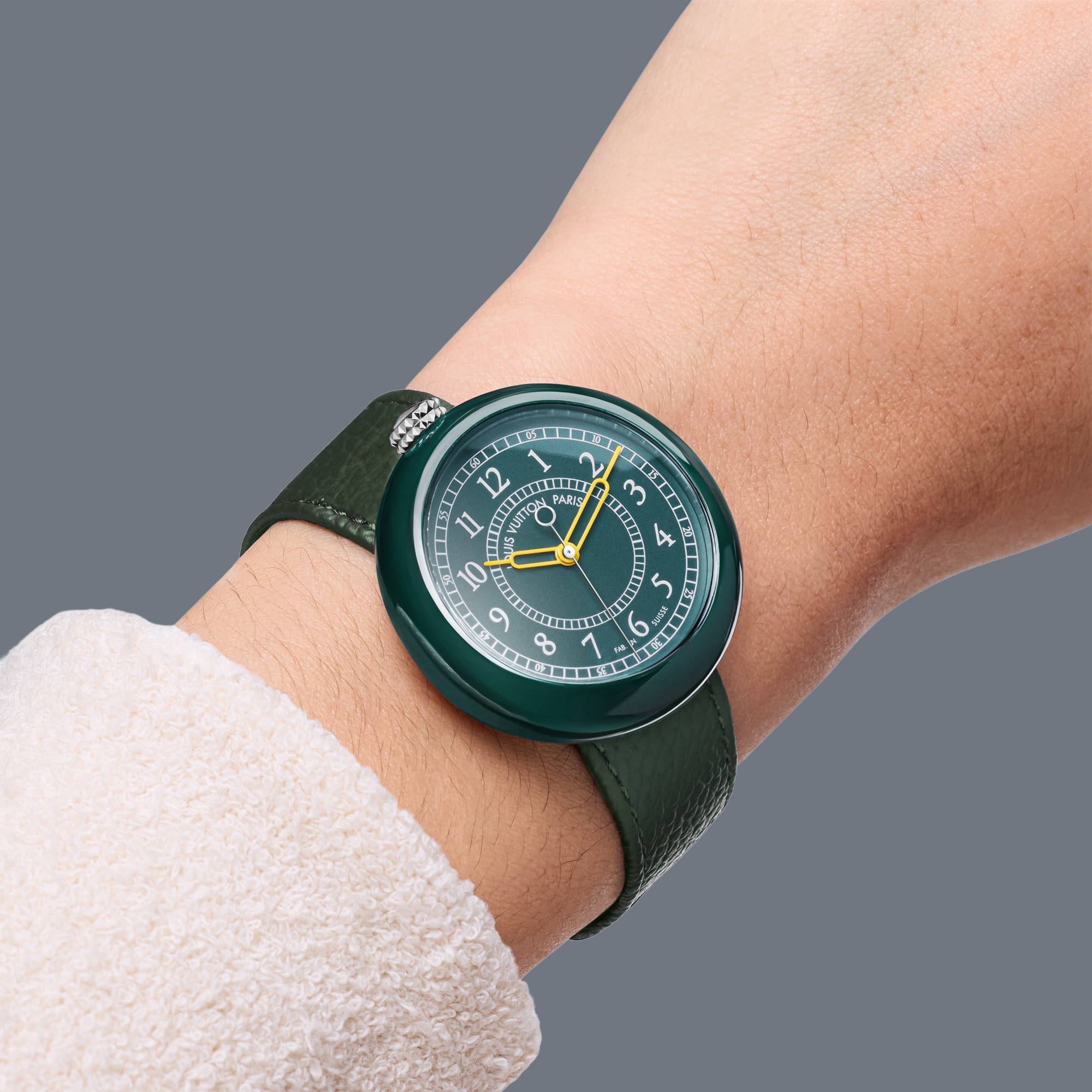 Green Louis Vuitton Monterey on a wrist, showing its rounded case, top-mounted crown and leather strap.
