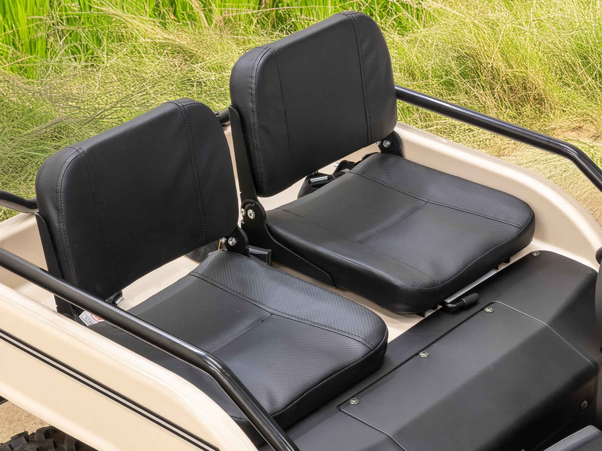Two padded seats in the cream Massimo Mini Truck, with the driver's seat adjustment visible