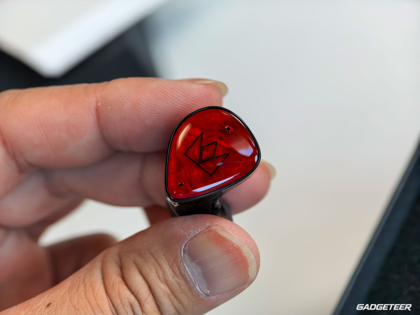 Close-up of the Noble FoKus Amadeus red faceplate held between fingers