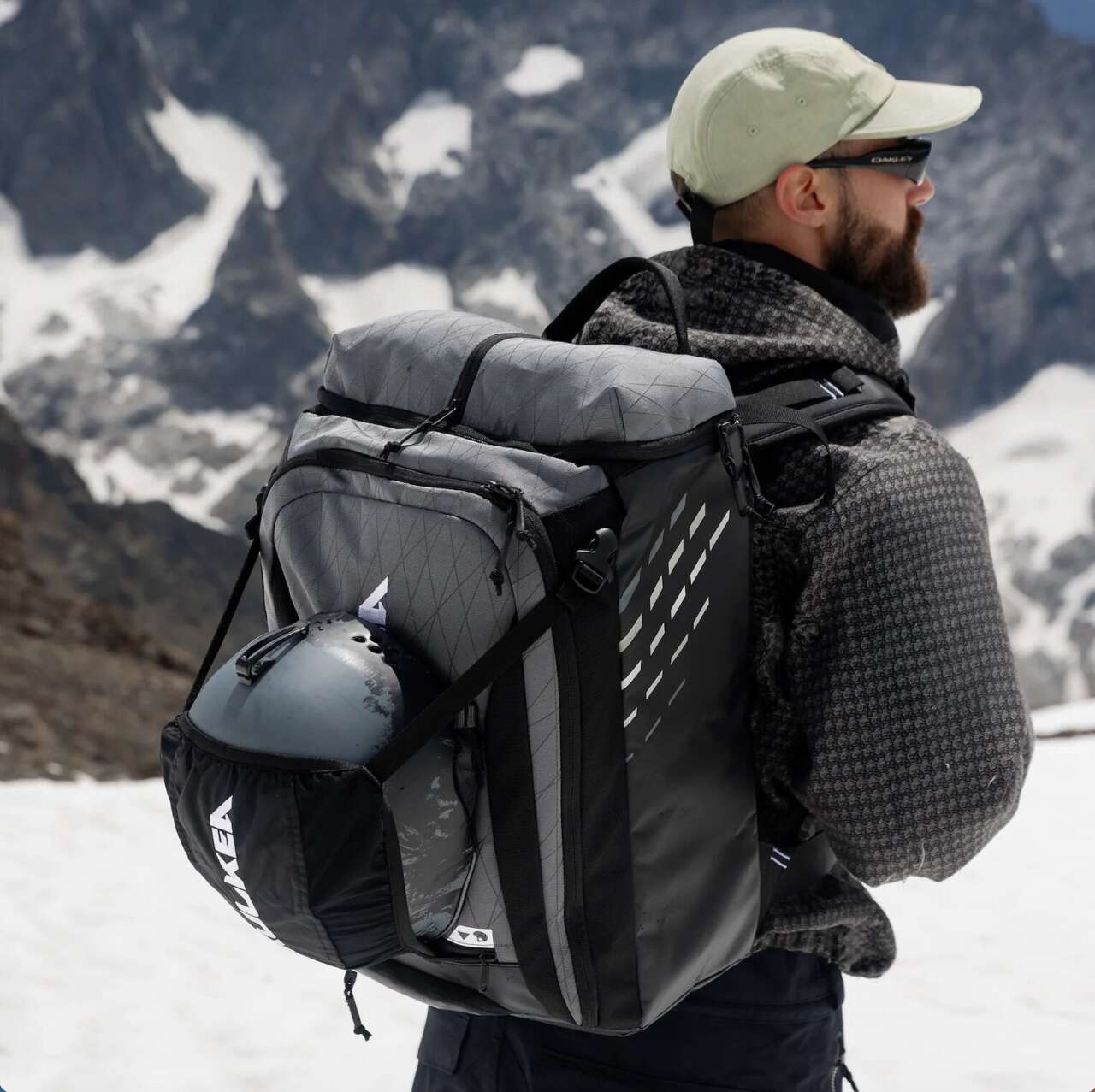 Skier wearing the Kulkea Thermal Kart backpack with a helmet in its exterior sling