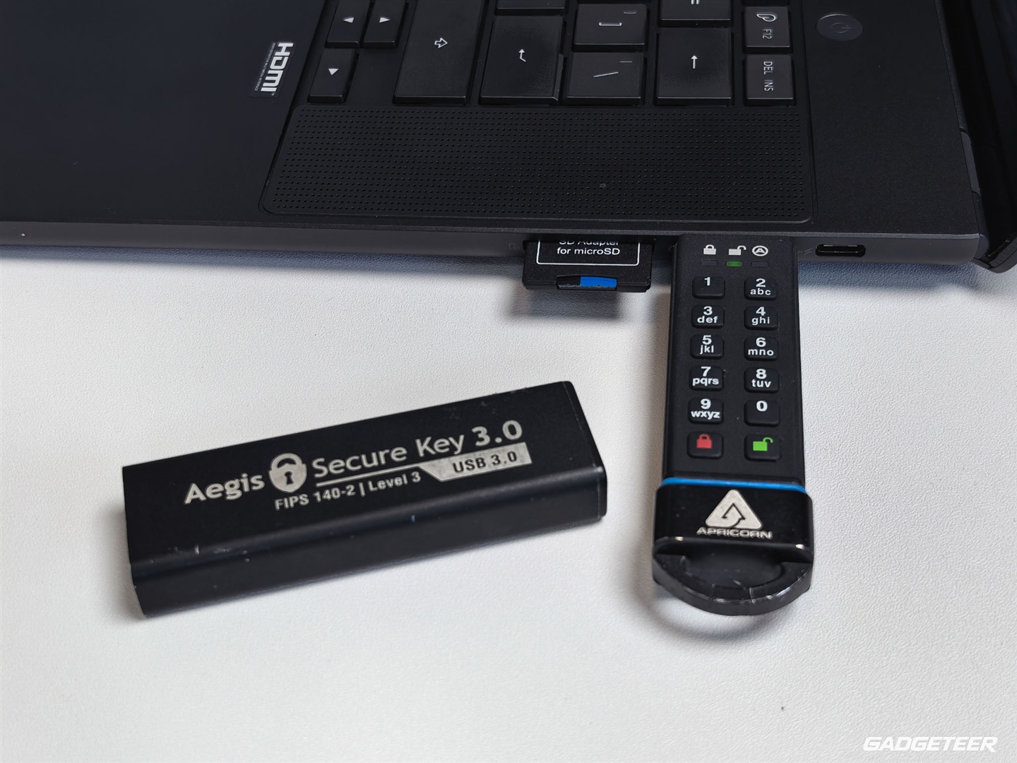 Apricorn Aegis Secure Key 3.0 connected to the ASUS ProArt P16 beside an SD adapter and USB-C port.