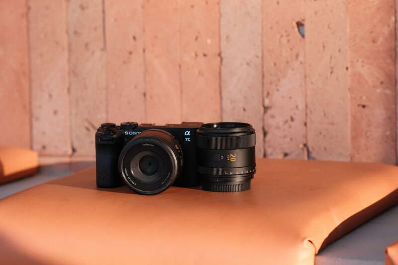 Sirui Swift 40mm F2.2 on a Sony camera beside the Swift 20mm F2.4 on an orange bench