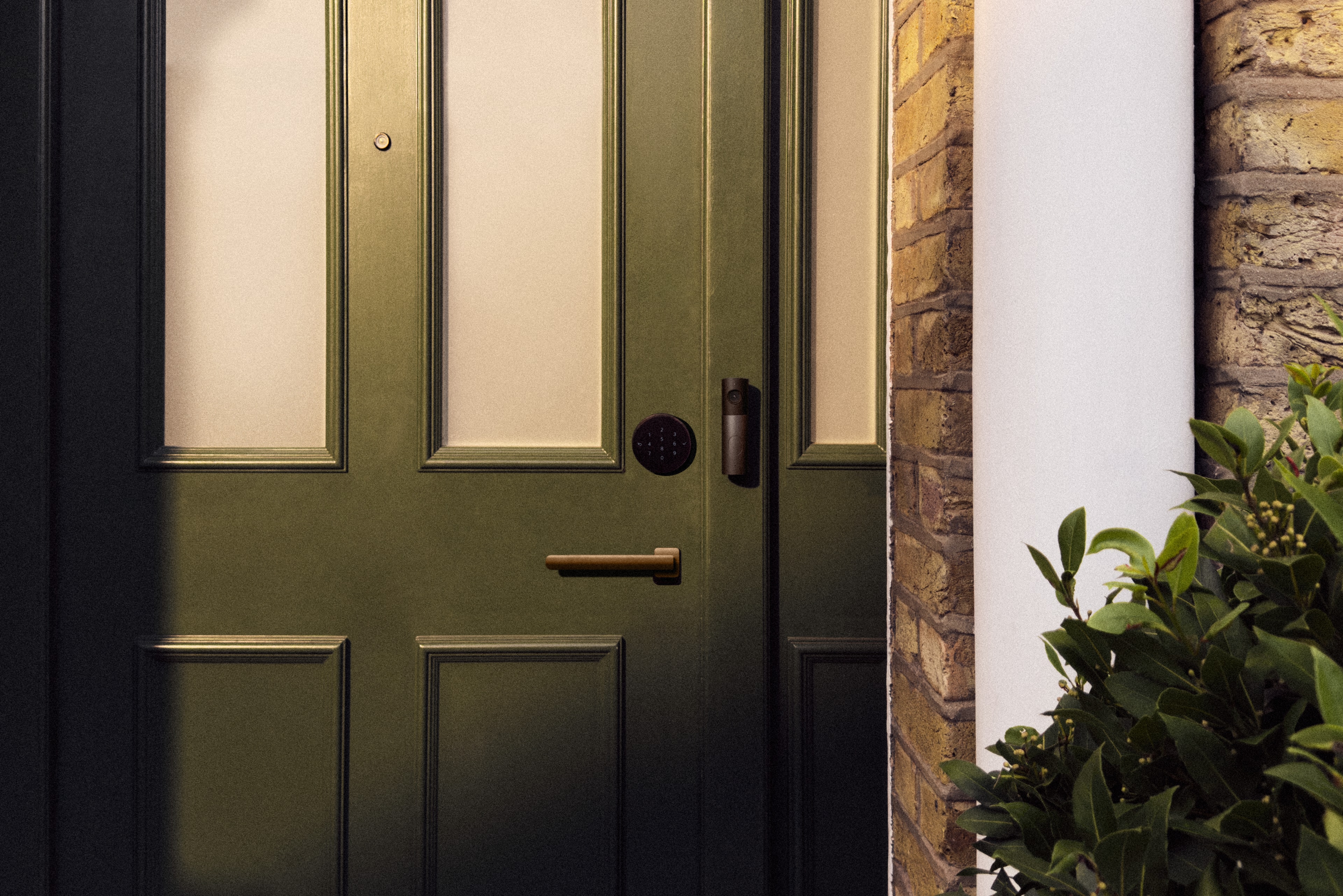 LG Home Collection doorbell and smart deadbolt outside a home's front door.