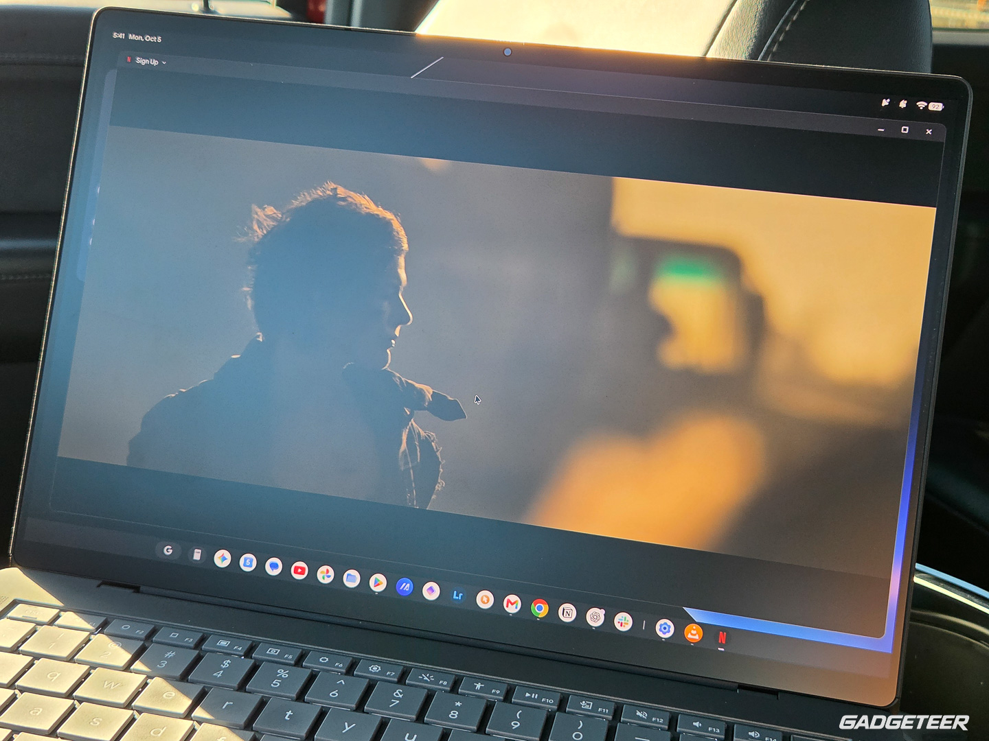 Reflected daylight spreads a pale haze across a dark movie scene on the ASUS Googlebook 14.