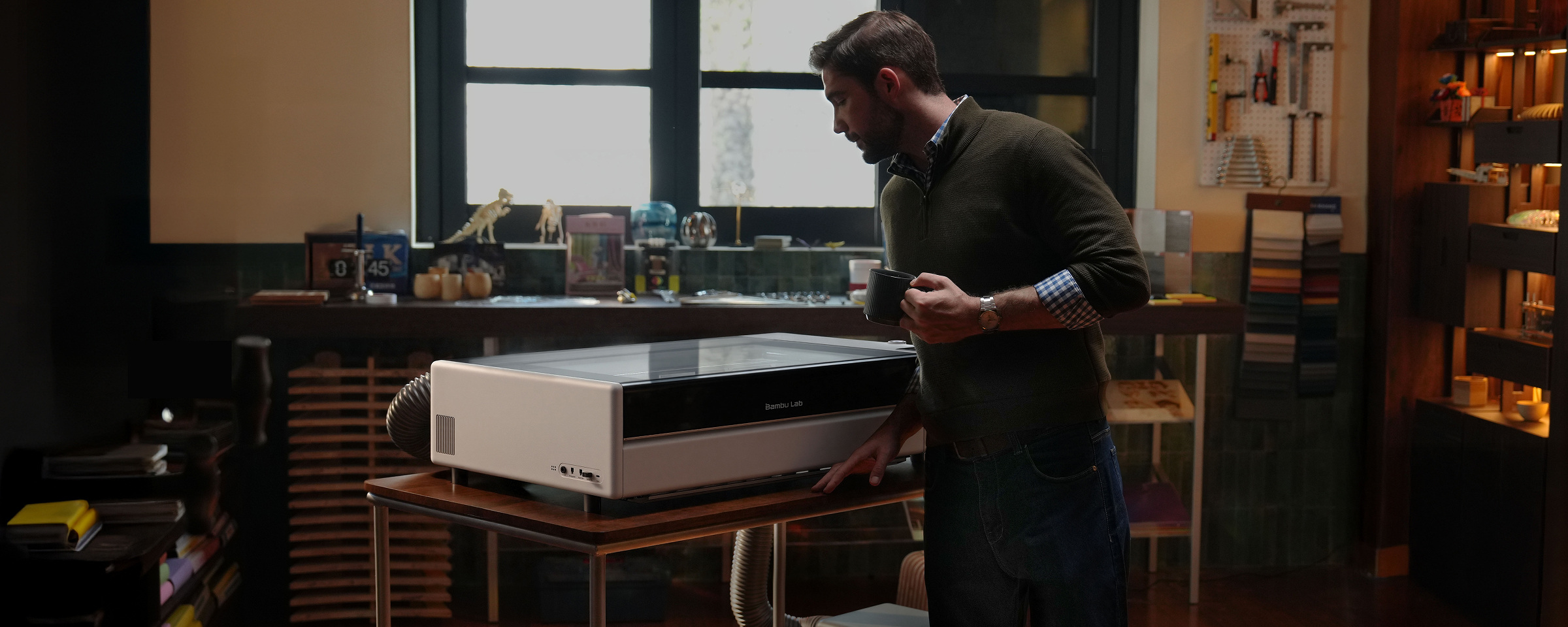 Bambu Lab R1 enclosed laser cutter in a manufacturer-supplied workshop scene