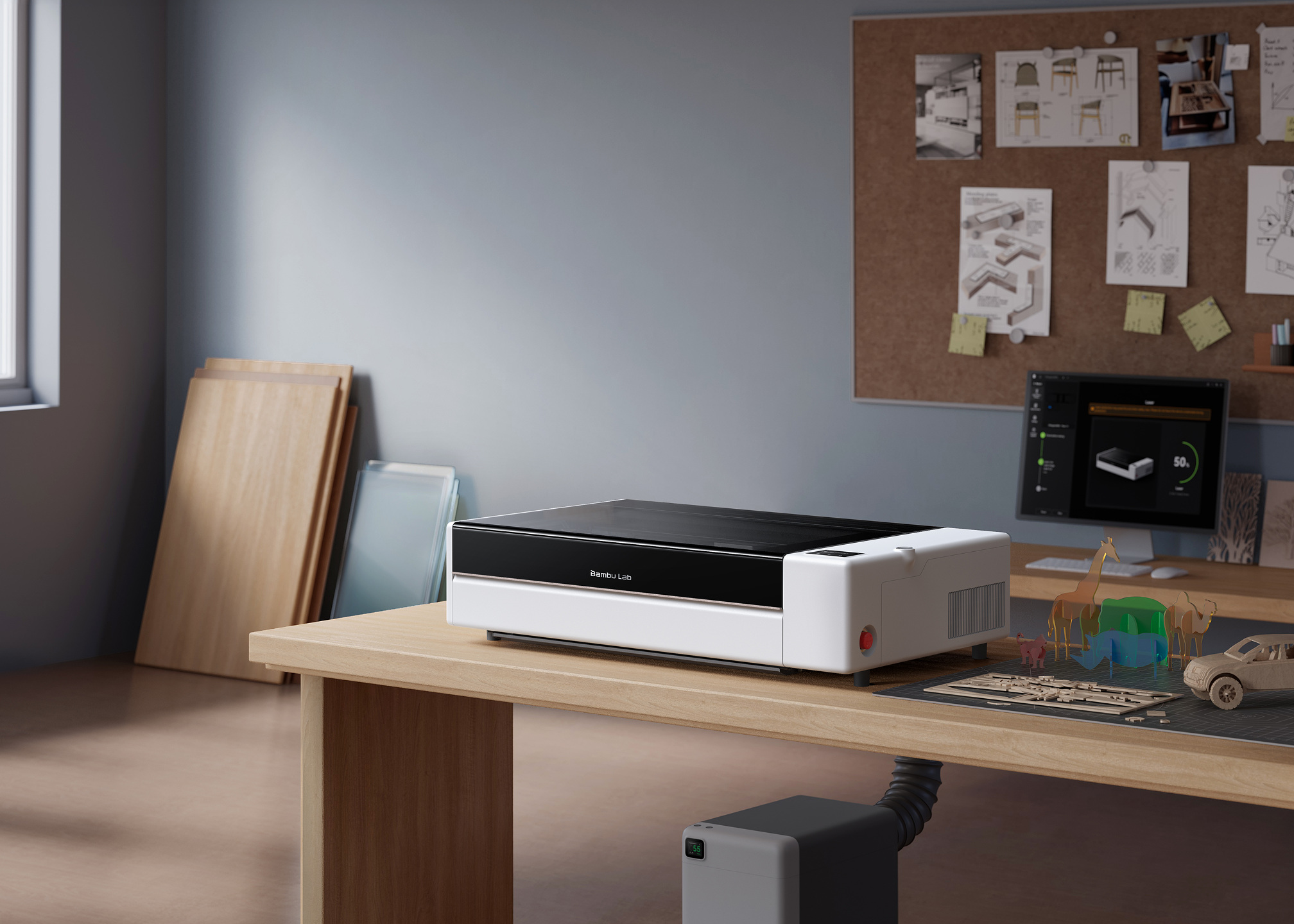 Bambu Lab's workshop image shows the R1 with sheet materials and example projects. The purifier pictured below the bench is sold separately.