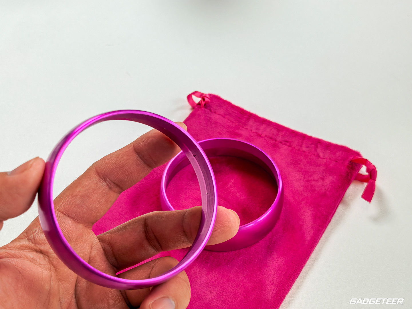A pink Chilipad accessory ring held above a pink storage pouch
