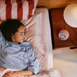 Coral Pink Echo Time on a bedside table beside a person waking, official Amazon lifestyle photograph