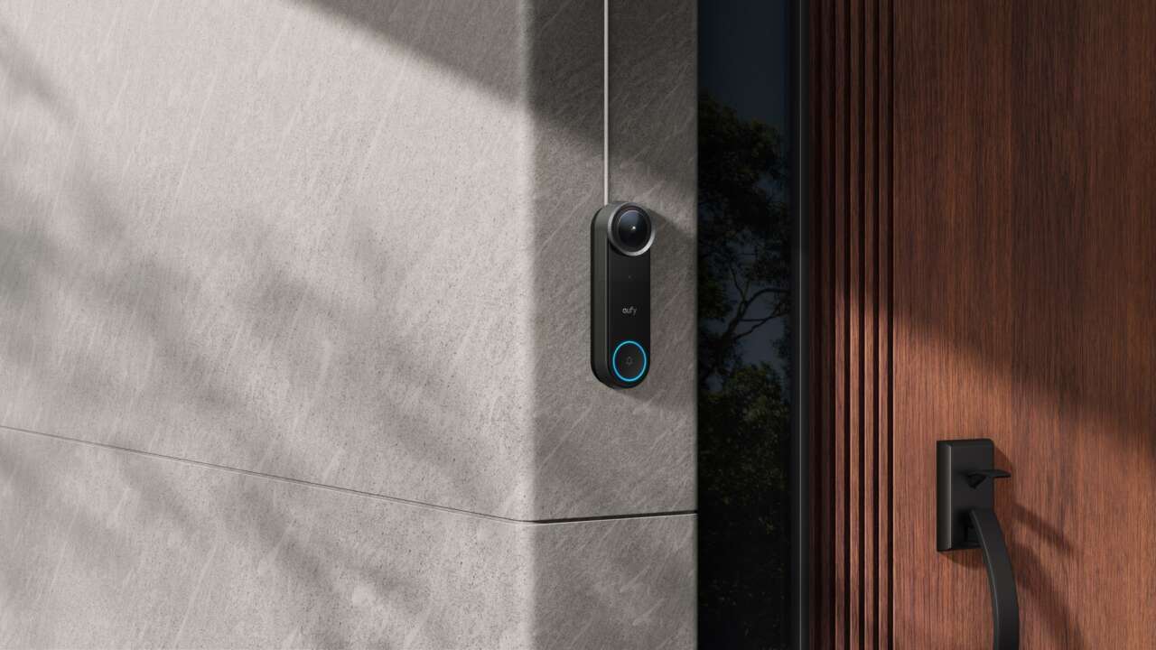 eufy Video Doorbell S4 mounted beside a wooden front door.