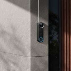eufy Video Doorbell S4 mounted beside a wooden front door.