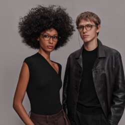 Two models wearing Even G2 Brown 2 glasses, with a chain attached to the round frame.