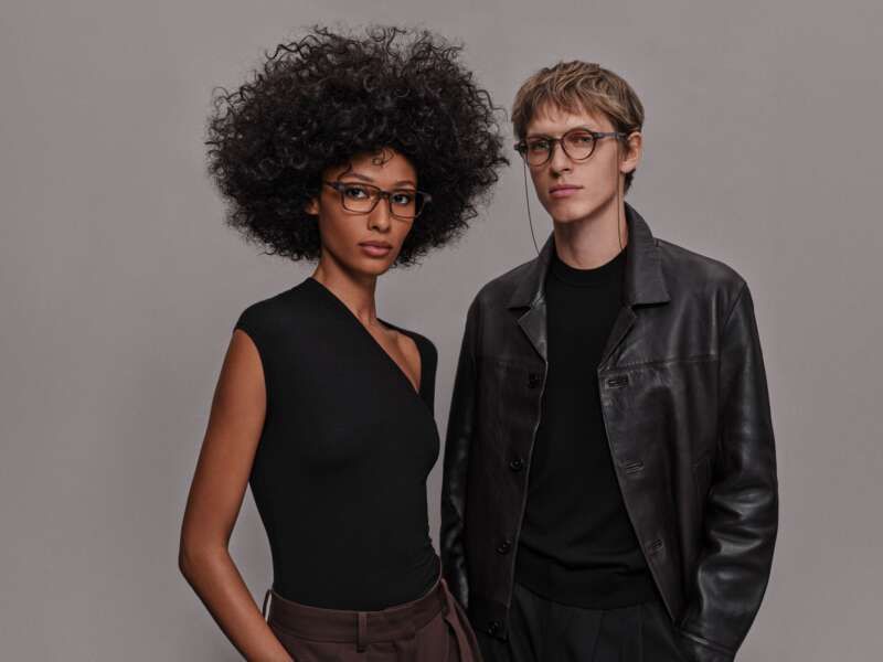 Two models wearing Even G2 Brown 2 glasses, with a chain attached to the round frame.