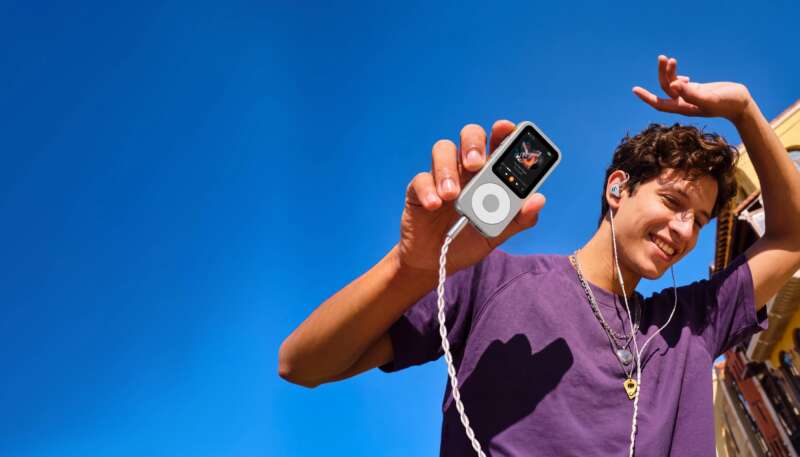 Fosi DAP Neo music player held outdoors with wired earphones connected