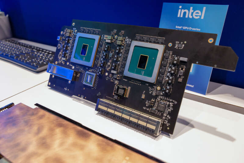 Exposed accelerator boards and chips beside an Intel GPU D-series sign at Intel’s OCP booth.