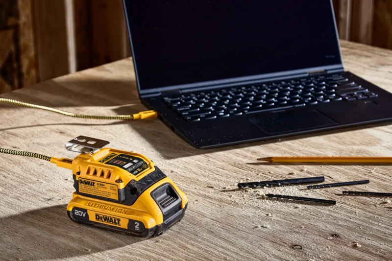 DeWalt DCB094 USB charger on a battery beside a connected laptop
