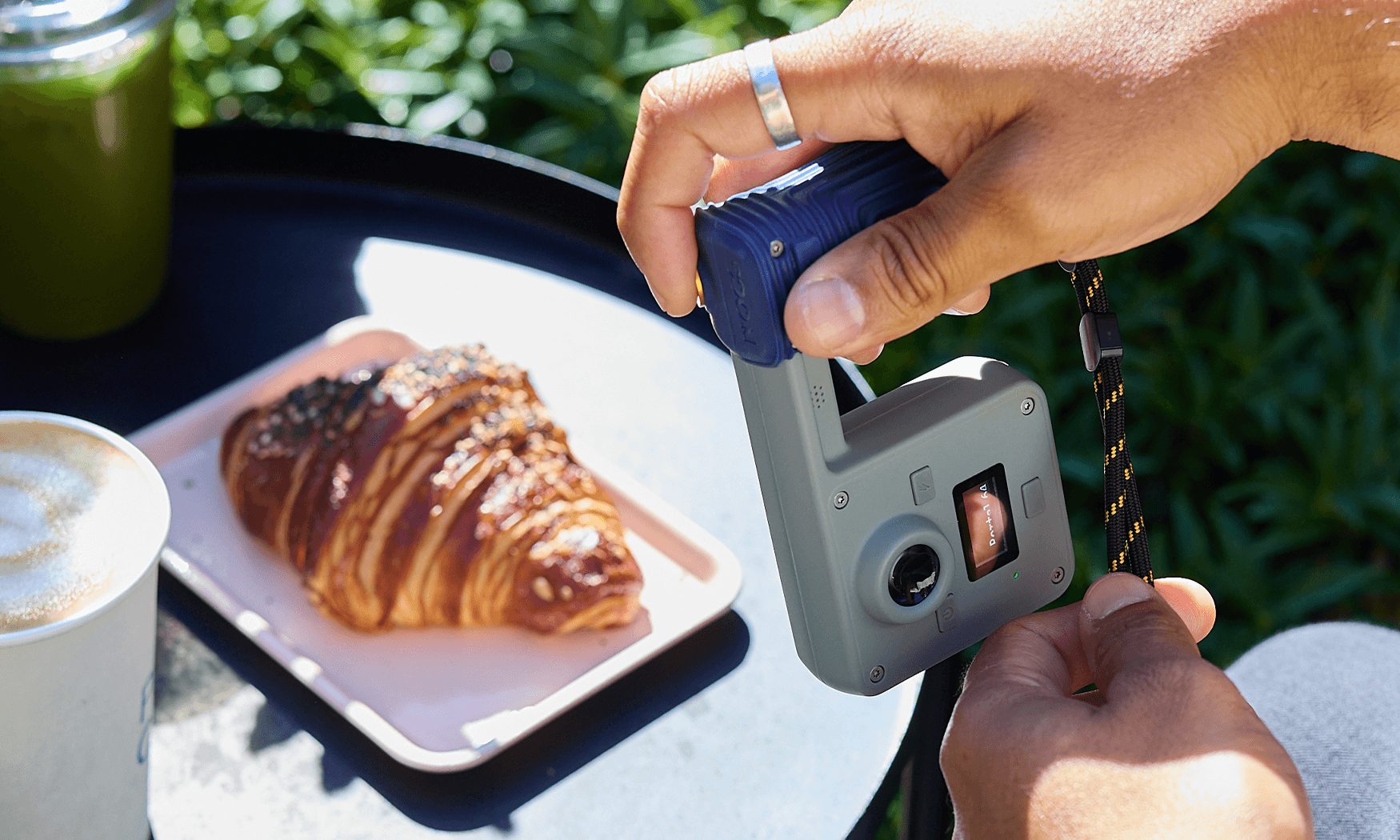 Nocs Portal AFN7 adventure camera held at an outdoor table.