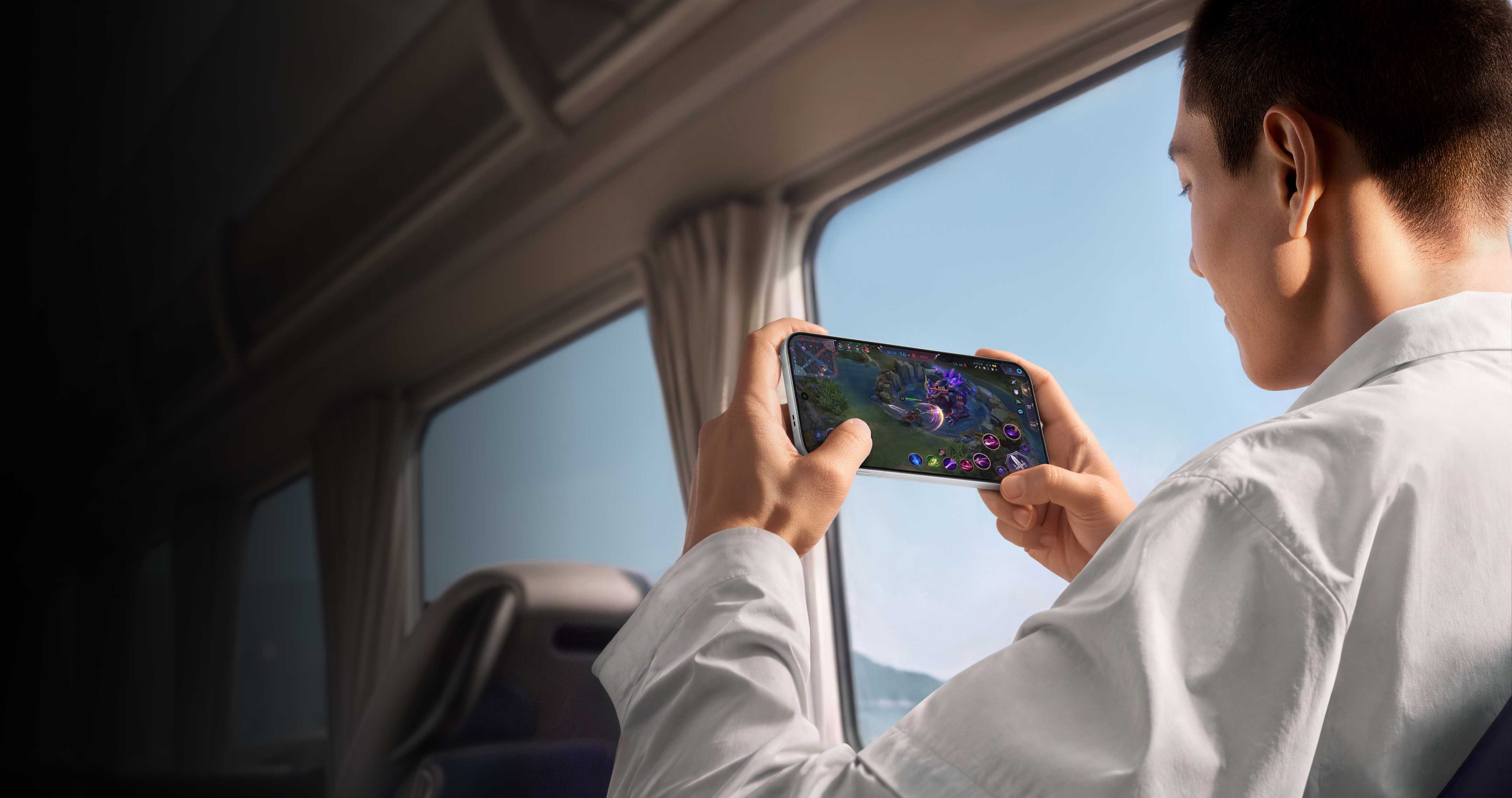 Person playing a game on an OPPO Find X10 Pro Max beside a train window.