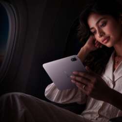 A woman holding the lavender OPPO Pad Mini in an airplane cabin.