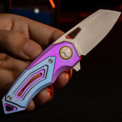 RAVEN-T anodized titanium folding knife held open in a creator-supplied photograph