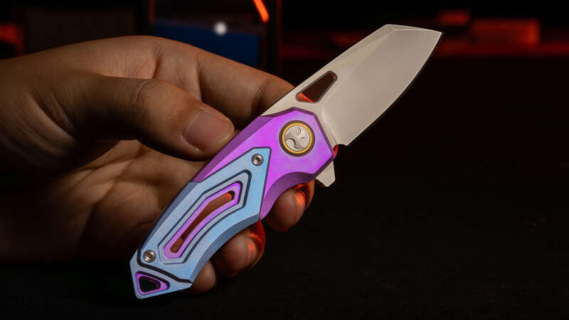 RAVEN-T anodized titanium folding knife held open in a creator-supplied photograph