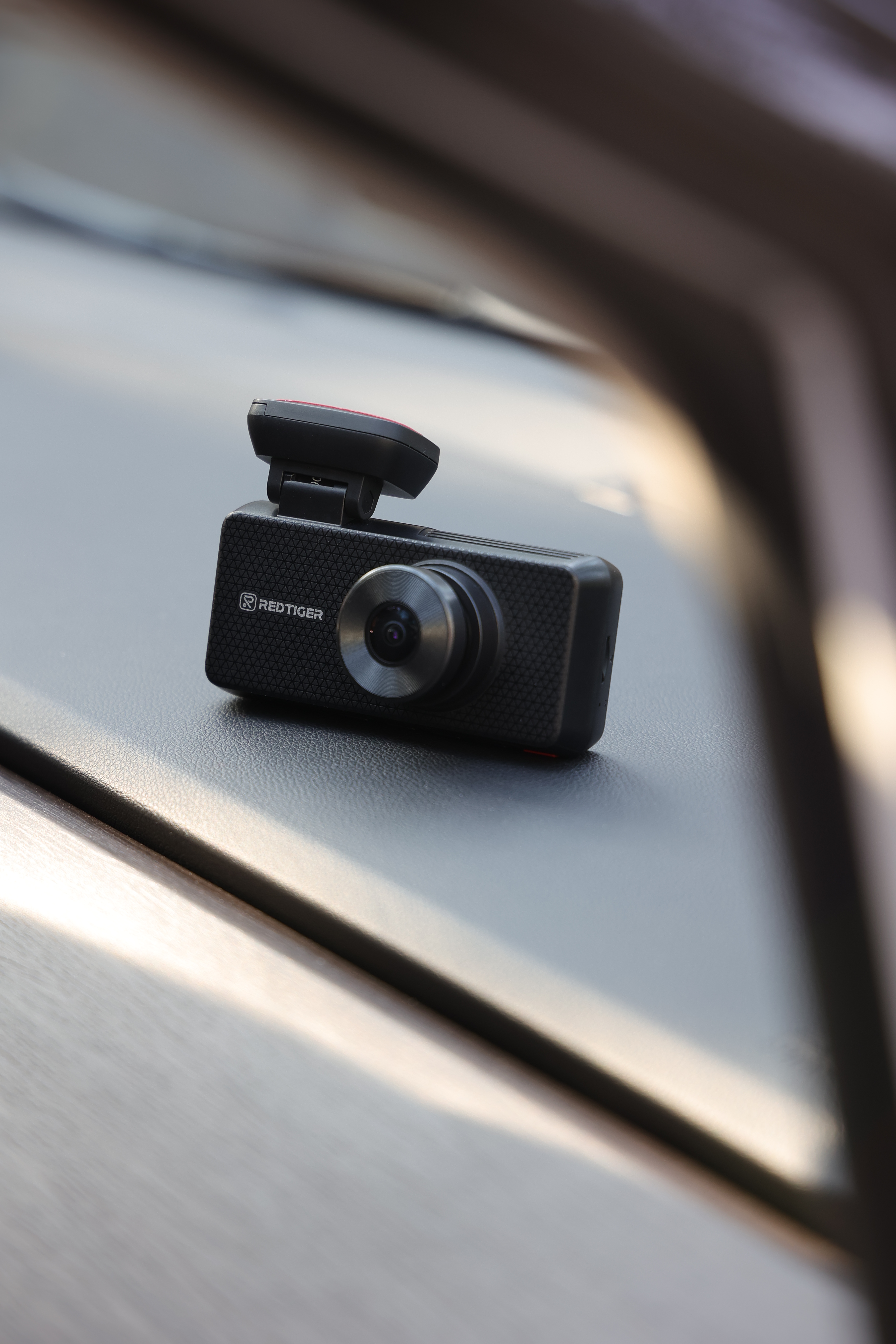 Front-facing lens on a black REDTIGER F17 Elite resting on a car dashboard