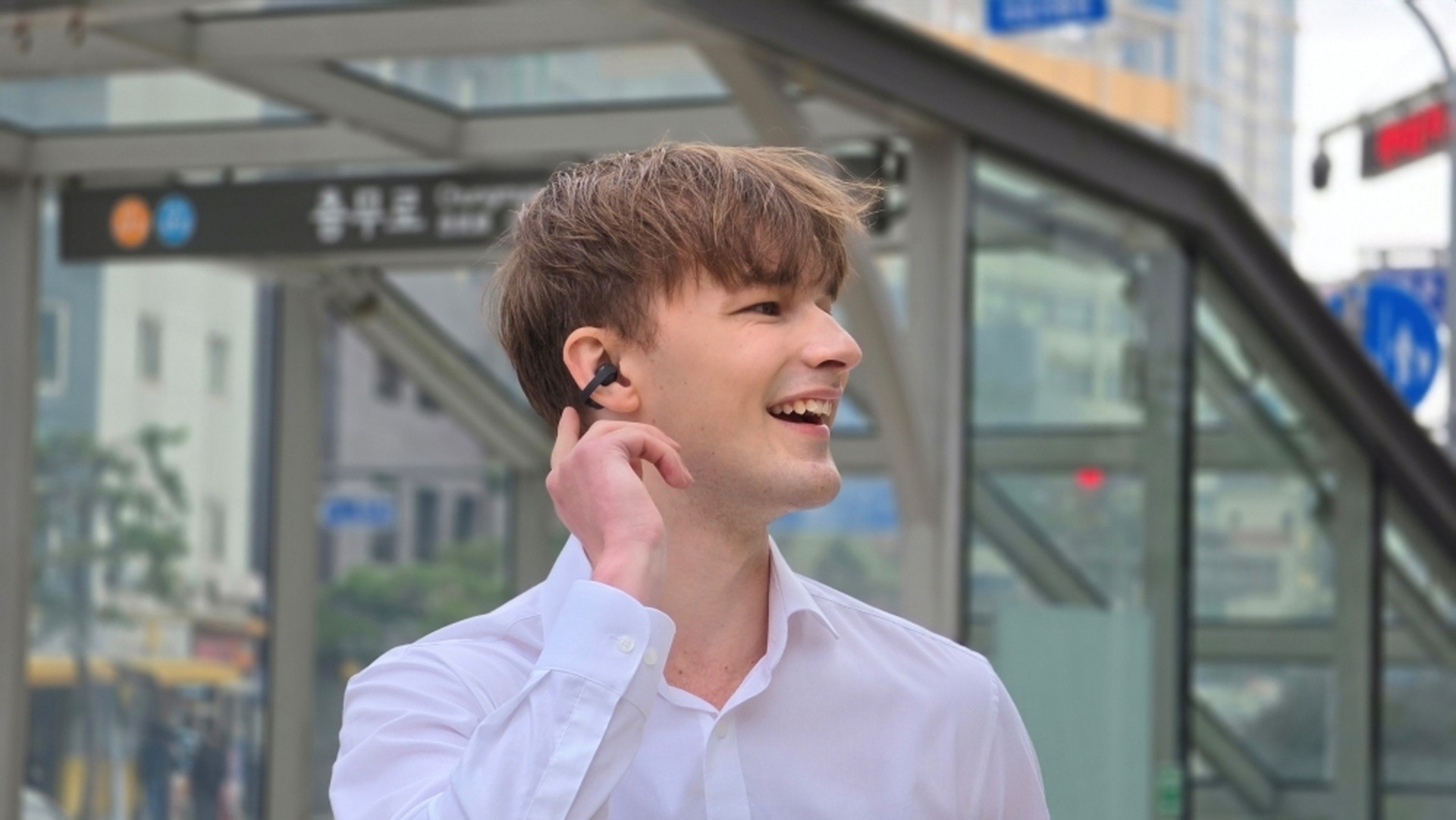 Man using Samsung Galaxy Buds On for a call near a subway entrance