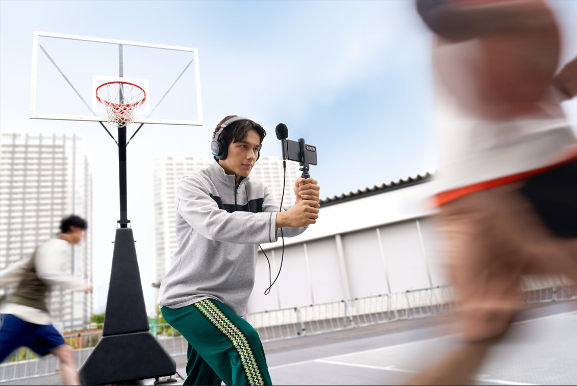 Creator filming basketball with a Sony ECM-AX10 microphone and smartphone