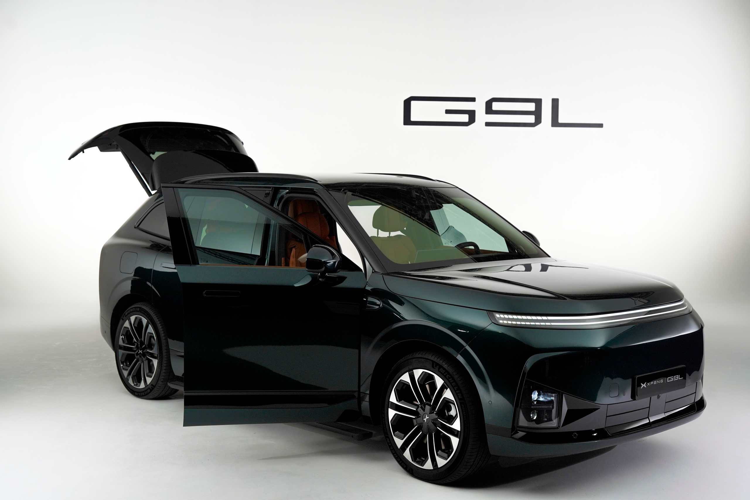 Green G9L in the studio with its doors and tailgate open, showing the Tangerine cabin.