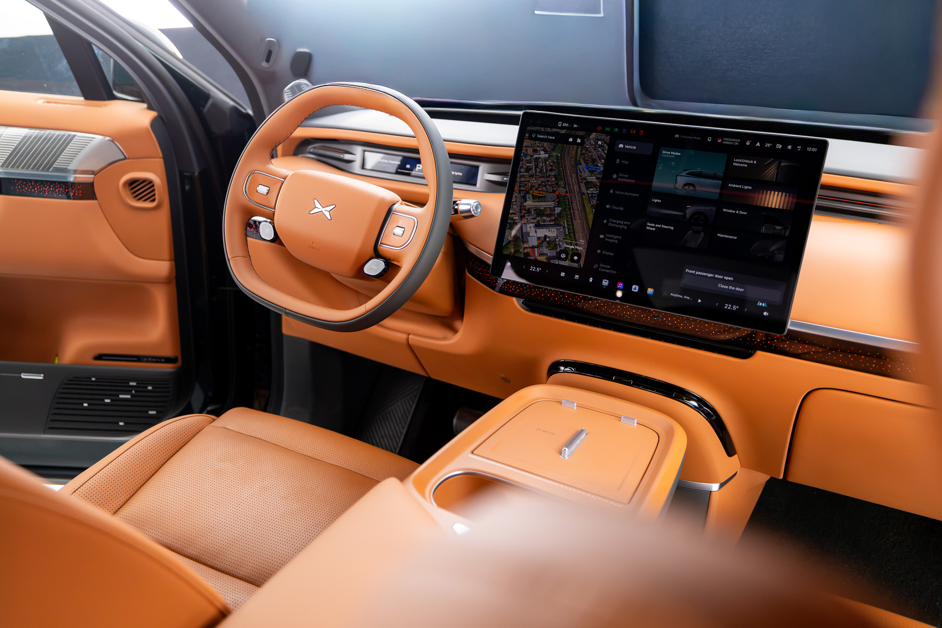 XPENG G9L Tangerine cockpit with its steering wheel, central touchscreen, and front center console.